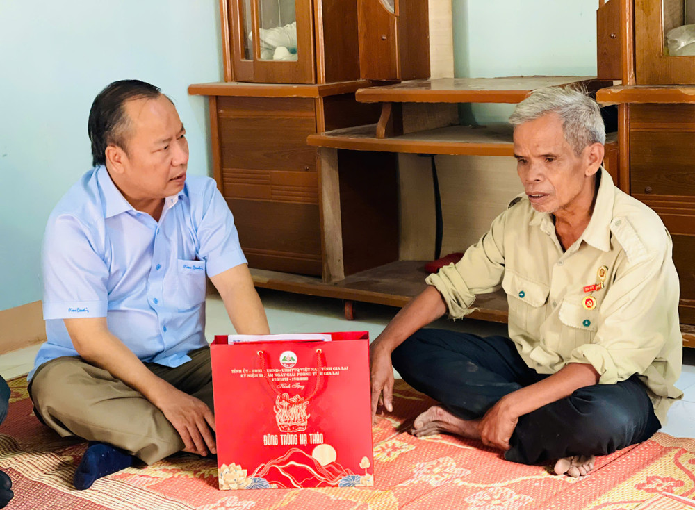 Phó Bí thư Thường trực Tỉnh ủy Châu Ngọc Tuấn (bìa trái) ân cần hỏi thăm sức khỏe ông Đinh Bưk (bệnh binh, làng Đăk Hway, xã Đăk Tơ Pang). Ảnh: T.D dinh-blkuk.jpg