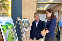 Các đại biểu ngắm một số tác phẩm nhiếp ảnh được trưng bày tại buổi lễ. Ảnh: Lam Nguyên