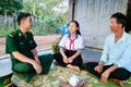 Thiếu tá Nguyễn Văn Luân (bìa trái) động viên em Nguyễn Thị Thảo Nguyên là "Con nuôi Đồn Biên phòng" cố gắng vượt khó học tập. Ảnh: P.D