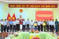 Phó Chủ tịch UBND tỉnh Nguyễn Tuấn Anh (thứ 10 từ phải sang) tặng quà của Tỉnh ủy, HĐND, UBND, Ủy ban MTTQ Việt Nam tỉnh cho lãnh đạo và Công an phường Hoài Nhơn Tây. Ảnh: Phi Long