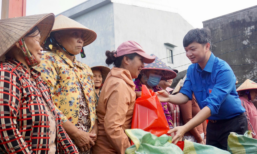 Anh Nguyễn Minh Triết tặng quà cho người dân xóm Cồn Chim. Ảnh: D.L
