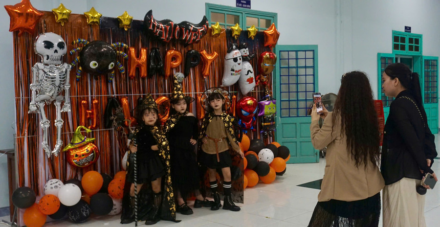 Phụ huynh tranh thủ "check-in" cho con trẻ trước đêm dạ hội hóa trang. Ảnh: D.L halloween-ngap-tran-tieng-cuoi-5.jpg