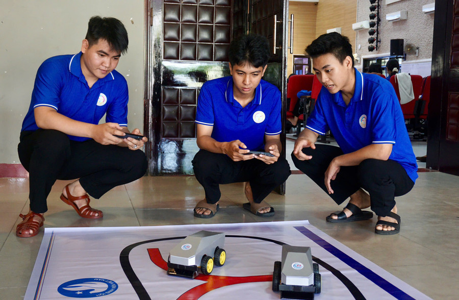 Tuyển (bìa phải) cùng trao đổi nguyên lý hoạt động mô hình “Trường đua AI” với các bạn. Ảnh: D.L chuyen-doi-so-2025-8.jpg
