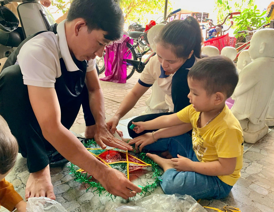 Anh May cùng làm đèn lồng với trẻ tại Niệm Phật đường Mỹ Hóa. Ảnh: ĐVCC z6820468444645-c1f7739e49a83d12ddfd428c4da22340.jpg