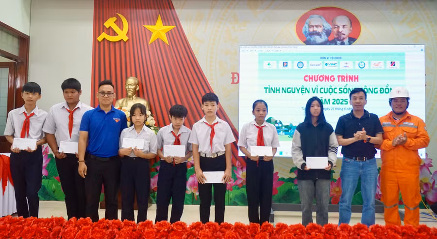 Tặng thẻ bảo hiểm y tế cho học sinh trung học cơ sở ở xã Tuy Phước Tây. Ảnh: D.L
