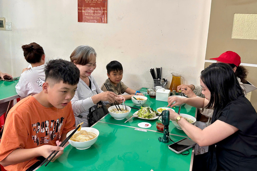 Bà Xuân (áo trắng) cùng người thân thưởng thức bún cá. img-8127.jpg