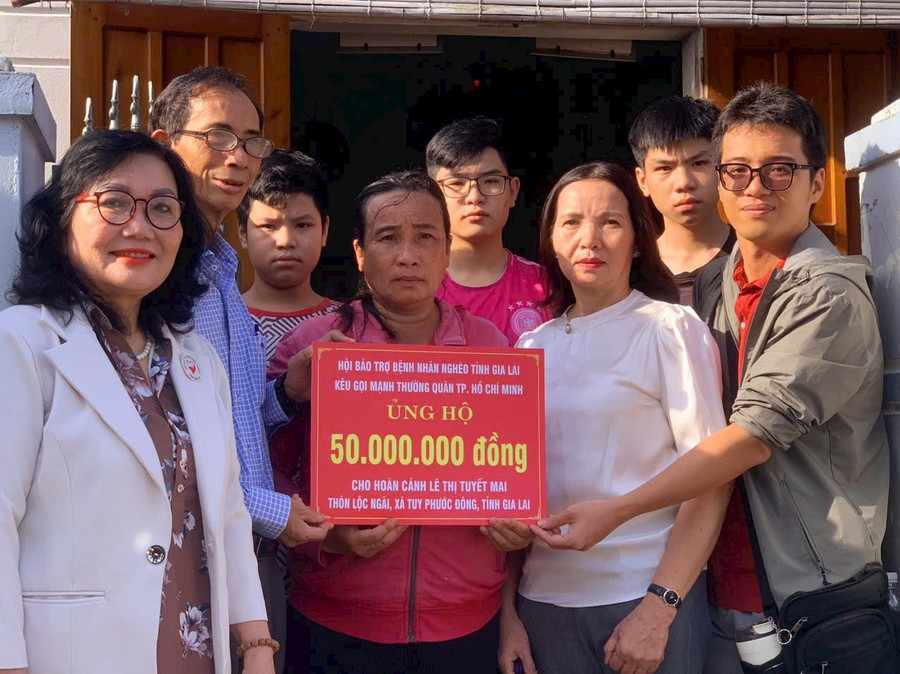 Đại diện Hội Bảo trợ bệnh nhân nghèo tỉnh Gia Lai cùng nhà hảo tâm trao bảng tượng trưng hỗ trợ cho bà Mai. Ảnh: ĐVCC img-7691.jpg