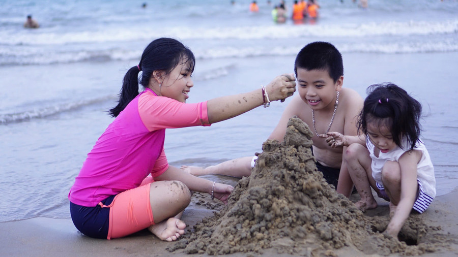 Trẻ em vừa xây lâu đài cát, vừa cười khoái chí. Ảnh: D.L img-7345.jpg