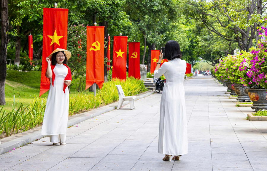 Người dân, du khách tranh thủ check in với cờ đỏ sao vàng trên đường Nguyễn Tất Thành. dungnhan3.jpg