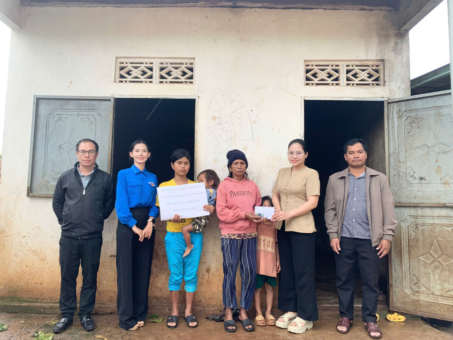 Đại diện Báo và Phát thanh, truyền hình Gia Lai và chính quyền địa phương trao tiền hỗ trợ cho gia đình em Ên. Ảnh: Chu Hằng en.jpg