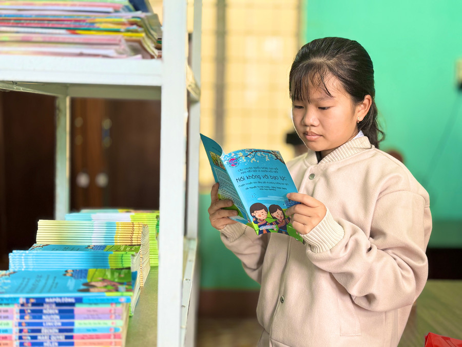 Em Bùi Phương Vy (học sinh lớp 8B, Trường THCS Lê Hồng Phong) hào hứng đọc sách tại thư viện Nhím Xanh. Ảnh: Lạc Hà img-6884.jpg