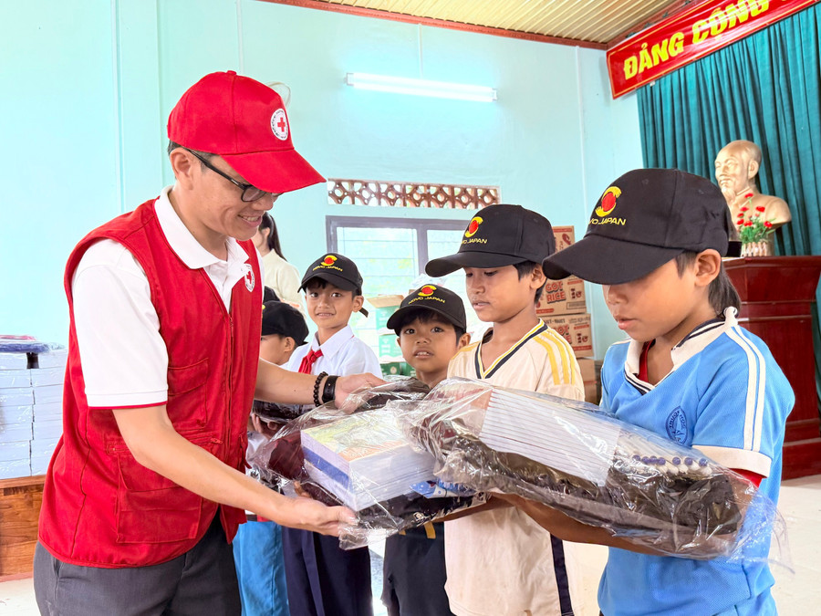 Ông Nguyễn Chí Cẩn, Phó Chủ tịch Hội Chữ thập đỏ tỉnh Gia Lai, trao quà cho các em học sinh có hoàn cảnh khó khăn trên địa bàn xã Lơ Pang. Ảnh: Lạc Hà ncc.jpg