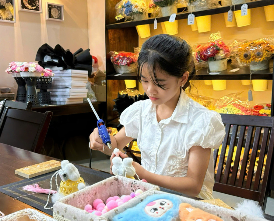 Em Bùi Nguyễn Thảo Vy (12 tuổi, học sinh Trường THCS Nguyễn Du, phường Diên Hồng) thích thú với hoạt động làm lồng đèn trung thu. Ảnh: Minh Thư thao-vy.jpg
