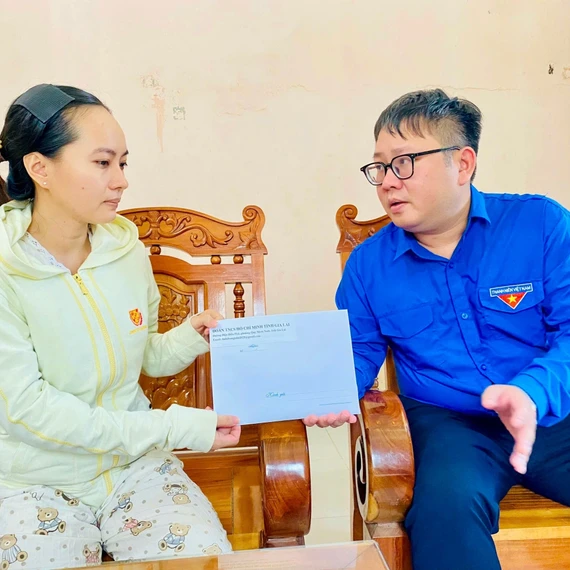 Phó Bí thư Tỉnh đoàn Nguyễn Chí Hiếu (bìa phải) gửi lời chia buồn và trao tiền hỗ trợ cho người thân của anh Đinh Văn Quang. Ảnh: Bích Kiều