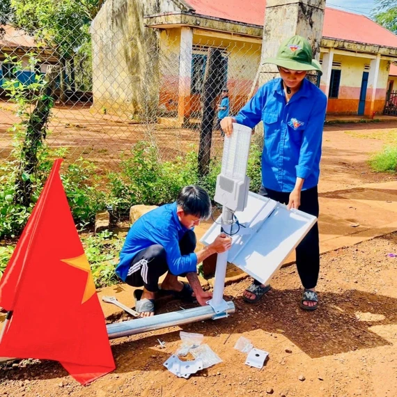 Đoàn viên, thanh niên lắp đặt trụ điện năng lượng trời để tặng người dân. Ảnh: ĐVCC