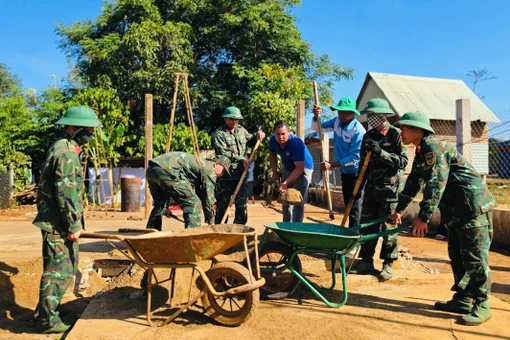 Cán bộ, chiến sĩ chung tay sửa chữa nhà cho người dân.