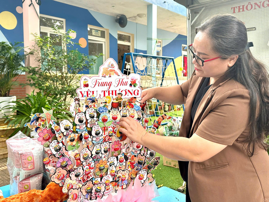 Chị Nay Hkram (mẹ của nhà gia đình “Hoa Tường Vi”, Làng Trẻ em SOS Pleiku) sắp xếp tháp bánh kẹo cho các con. Ảnh: Minh Chí chi-nay-hkram-lang-sos-pleiku-sap-xep-thap-banh-keo-don-tet-trung-thu.jpg