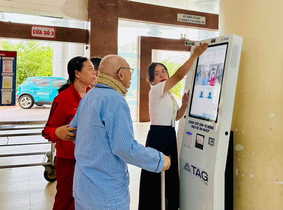 Nhân viên y tế Bệnh viện Đa khoa Trung tâm tỉnh hướng dẫn người dân sử dụng kiosk thông minh. Ảnh: Thảo Khuy 8.jpg