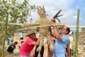 Ông Rmah Khiêm (bên phải) cùng người dân thôn Sô Ma Hang A làm hình nộm chuẩn bị cho lễ cúng bến nước. Ảnh: Vũ Chi