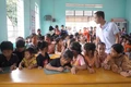 Thầy Lê Văn Bình hướng dẫn em đã biết chữ học tiếng Anh tại lớp học tình thương ở làng Khôi. 