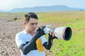 Phạm Công Quý say mê với chiếc máy ảnh trên một chuyến tác nghiệp. Ảnh: NVCC