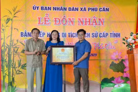Giám đốc Sở Văn hóa-Thể thao và Du lịch Trần Ngọc Nhung (bìa trái) trao bằng xếp hạng di tích cho địa phương. Ảnh: Minh Châu