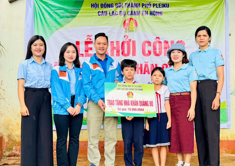 Đại diện Hội đồng Đội TP. Pleiku cùng Câu lạc bộ Cánh én hồng trao bảng tượng trưng nhà Khăn quàng đỏ cho 2 em thiếu nhi ở xã Biển Hồ. Ảnh: M.N img-2904-3095.jpg