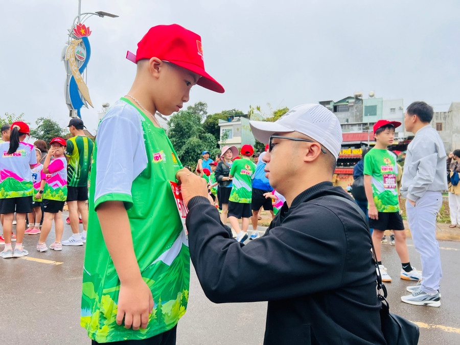 Phụ huynh chỉnh sửa áo quần cho con trước khi tham gia giải chạy. Ảnh: M.N 84980b26ed44a26f2b9792a52f4d3862.jpg