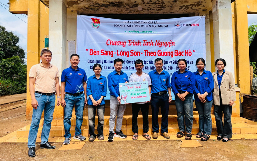 Đoàn cơ sở Công ty Điện lực Gia Lai trao bảng tượng trưng công trình Thắp sáng đường quê cho đại diện Chi bộ làng Chuk. Ảnh: M.N fe3e8bc64e128cd3ab0f2769ec180817-913.jpg