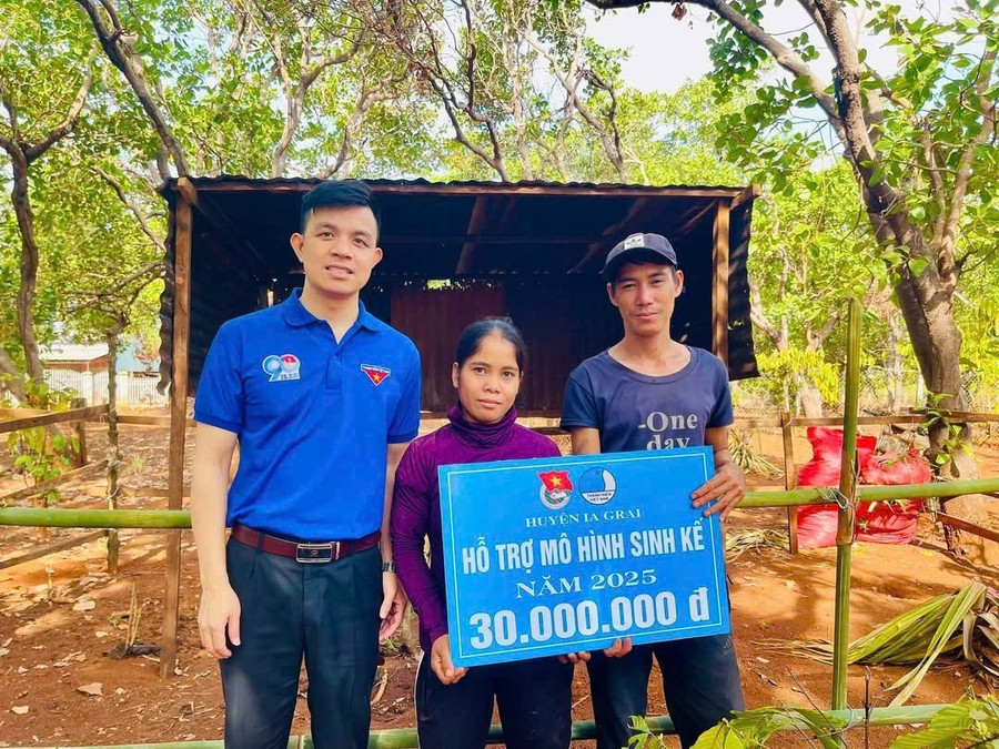 Anh Nguyễn Như Quang (bìa trái)-Phó Bí thư Huyện Đoàn Ia Grai trao bảng tượng trưng kinh phí hỗ trợ mô hình sinh kế cho chị Thik-thanh niên khó khăn ở xã Ia Grăng. Ảnh: N.Q img-1393.jpg
