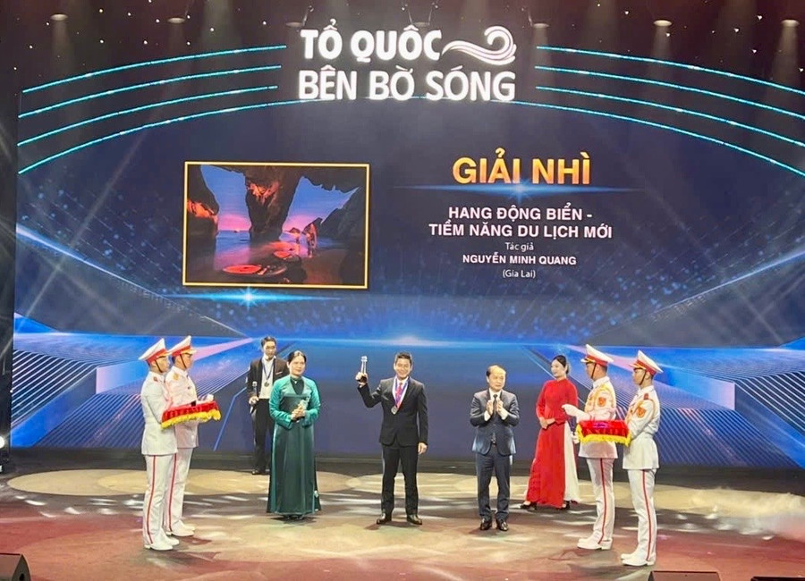 NSNA Nguyễn Minh Quang (ở giữa) nhận giải nhì hạng mục ảnh đơn với tác phẩm “Hang động biển-Tiềm năng du lịch mới”. Ảnh: NVCC nsna-nguyen-minh-quang-nhan-giai-nhi-cuoc-thi-to-quoc-ben-bo-song.jpg