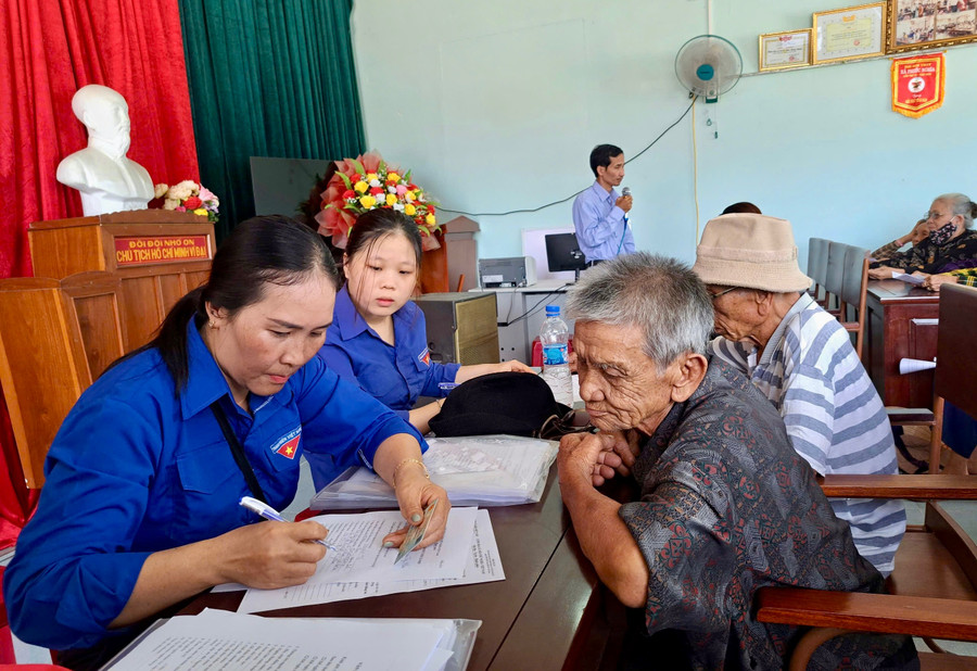 Đoàn viên, thanh niên xã Tuy Phước hỗ trợ người cao tuổi thực hiện các thủ tục hành chính. Ảnh: ĐVCC img-4790.jpg