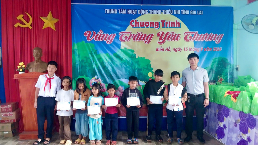 Em Vũ Hoàng Nam (bìa trái) tặng quà các bạn thiếu nhi ở làng Phung (xã Biển Hồ, TP. Pleiku). Ảnh: Minh Thu img-2128.jpg