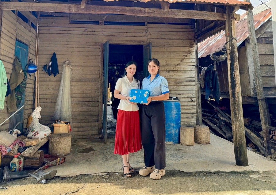 Cô giáo Hoàng Thị Diệu Loan (bìa trái) trao tiền và quà tặng cho em Siu H’Suyn. Ảnh: D.L img-4502.jpg