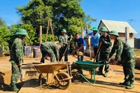 Cán bộ, chiến sĩ chung tay sửa chữa nhà cho người dân.