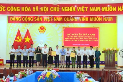 Phó Chủ tịch UBND tỉnh Nguyễn Tuấn Anh (thứ 6 từ trái sang) tặng quà cho lãnh đạo phường Hoài Nhơn. Ảnh: Phi Long
