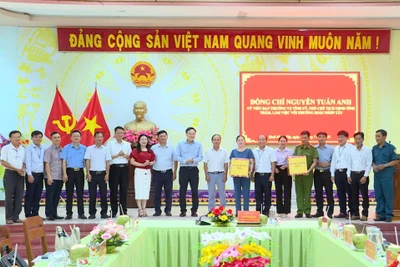 Phó Chủ tịch UBND tỉnh Nguyễn Tuấn Anh (thứ 10 từ phải sang) tặng quà của Tỉnh ủy, HĐND, UBND, Ủy ban MTTQ Việt Nam tỉnh cho lãnh đạo và Công an phường Hoài Nhơn Tây. Ảnh: Phi Long