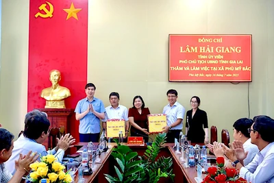Phó Chủ tịch UBND tỉnh Lâm Hải Giang tặng quà cho lãnh đạo xã Phù Mỹ Bắc. Ảnh: Bình Dương