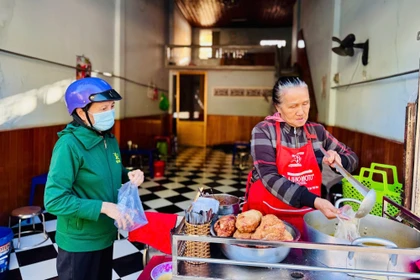 Bà Nguyễn Thị Thu Hồng (bìa phải) đang múc bánh canh cho khách. Ảnh: Thái Bình