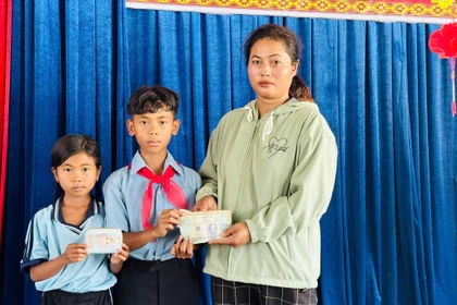 Em Nay Ti Mô Thê (đứng giữa) và Nay H’Ý trao trả lại số tiền nhặt được cho chị Rcom H’Nguyệt. Ảnh: ĐVCC