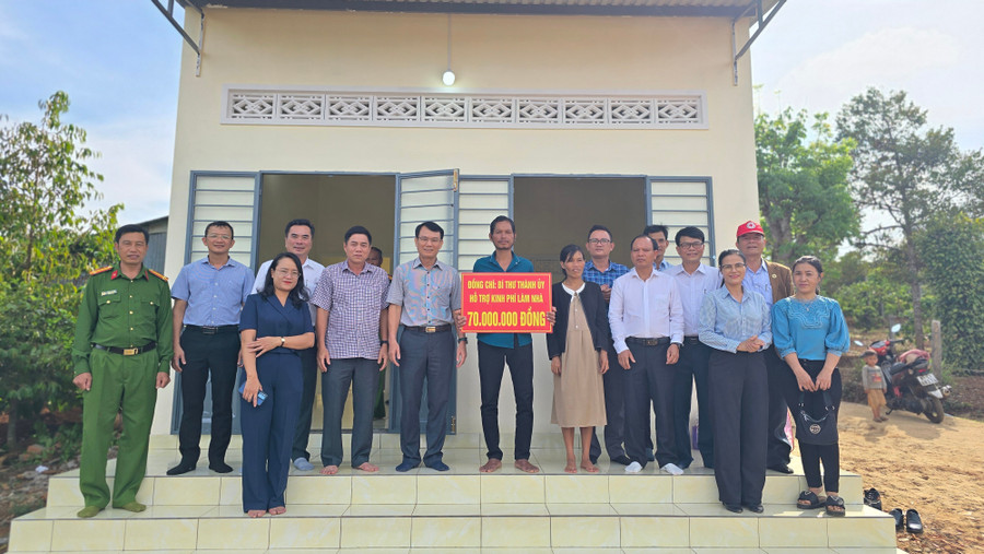 Bí thư Thành ủy Trịnh Duy Thuân (thứ 6 từ trái sang) cùng đoàn công tác bàn giao nhà ở cho gia đình ông Plơh tại làng Châm Anẻh (phường Chi Lăng). Ảnh: Bá Bính anh-1.jpg