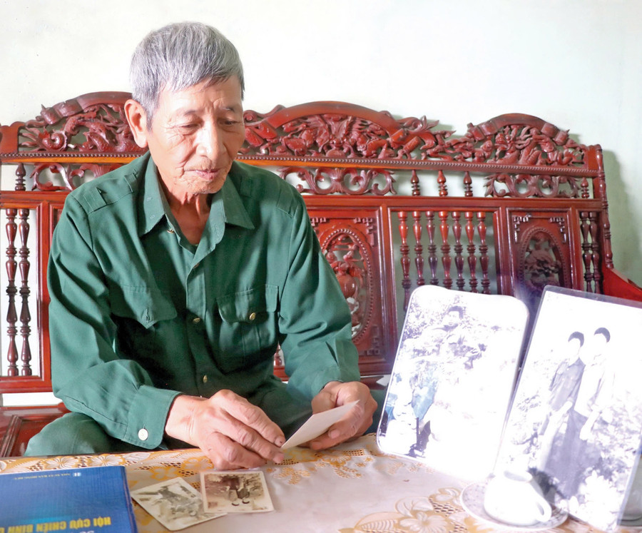 Ông Phạm Cao Đường (tổ 4, thị trấn Đak Pơ) xem lại những bức ảnh chụp trong thời gian tham gia giải phóng miền Nam. Ảnh: N.M z6555423827439-d0005a76ea4b2c49c85ff3bbc6748660.jpg