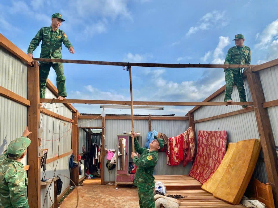 Các chiến sĩ giúp người dân lợp lại mái nhà. Ảnh: Kiên Quyết image.png