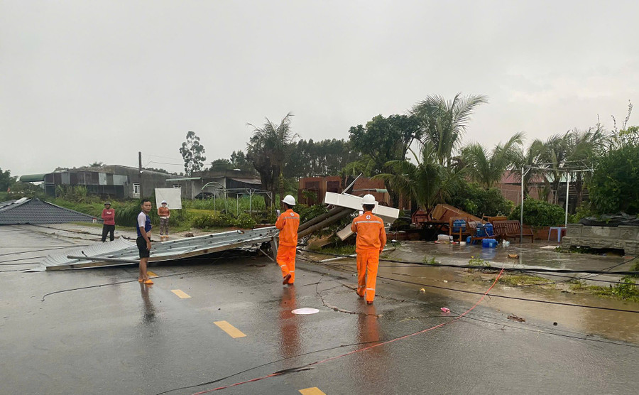 Nhân viên Điện lực Đak Pơ hỗ trợ người dân khắc phục hệ thống dây điện. Ảnh: K.P anh-2.jpg