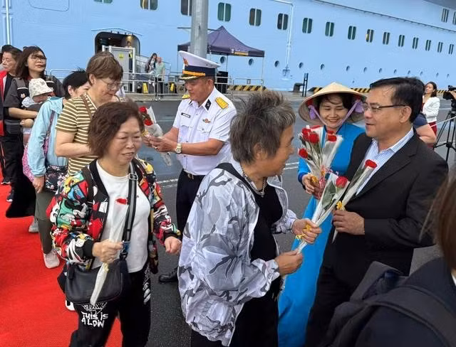 Lãnh đạo Hiệp hội Du lịch Khánh Hòa và Công ty TNHH Tân Cảng tặng hoa cho du khách trên tàu