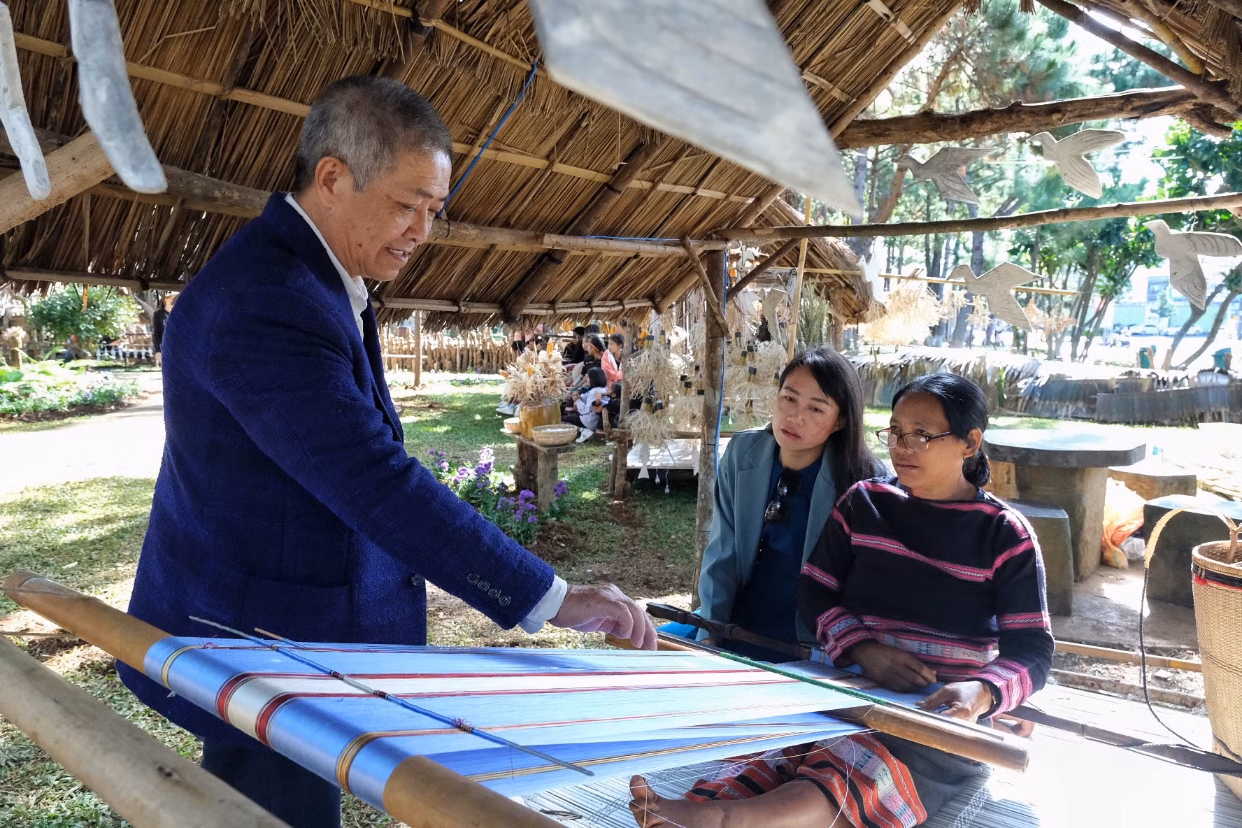 Ông Huỳnh Tấn Phước-Giám đốc Công ty Tơ tằm Nhật Minh cung cấp sợi tơ cho các nghệ nhân thực nghiệm trên khung dệt. Ảnh: Hoàng Ngọc