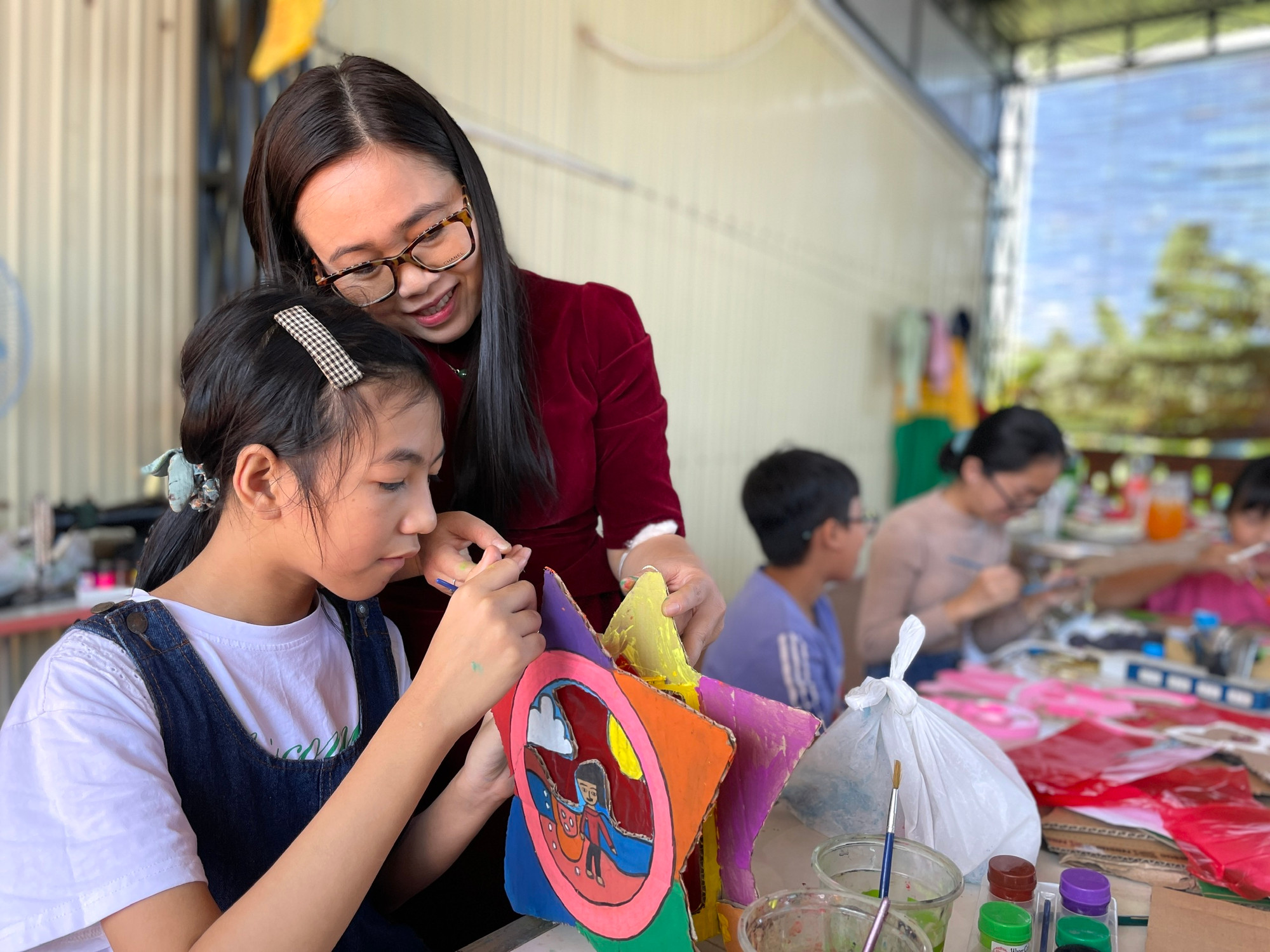 Nữ họa sĩ Nguyễn Nguyên Bút và học trò. Ảnh: Phương Duyên