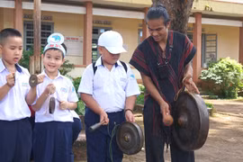 Học sinh say sưa trải nghiệm đánh chiêng, lắng nghe nghệ nhân kể chuyện về văn hoá cồng chiêng Tây Nguyên. Ảnh: Chu Hằng