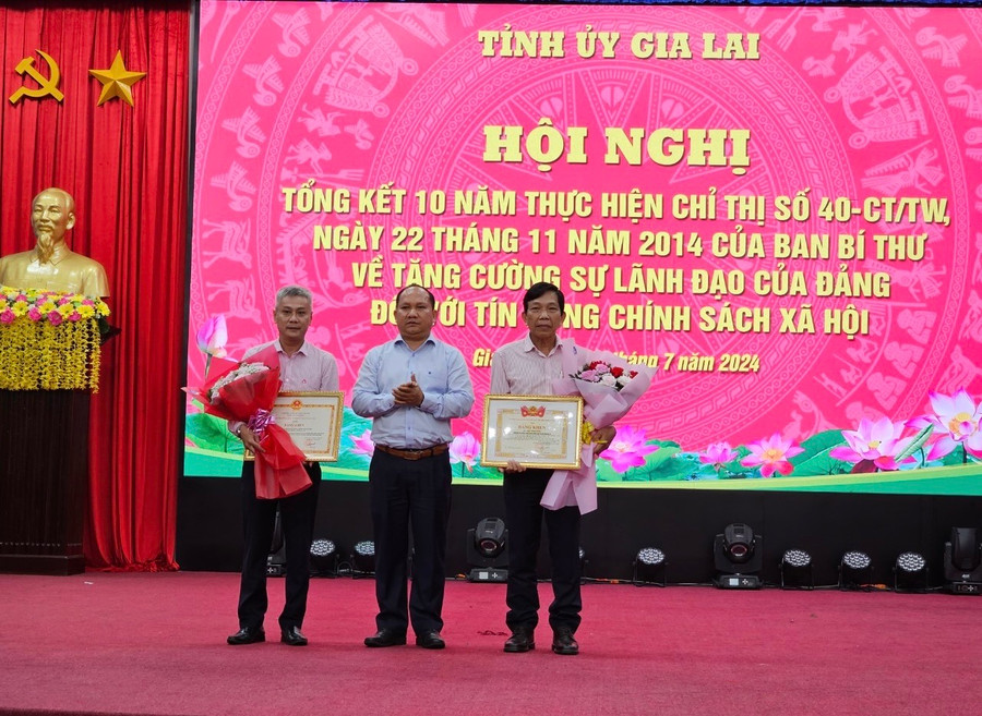 Đồng chí Rah Lan Chung-Phó Bí thư Tỉnh ủy chúc mừng đồng chí Lê Văn Chí và Phòng Giao dịch NHCSXH huyện Chư Prông được Trung ương Đoàn, Ủy ban Dân tộc khen thưởng. Ảnh: Sơn Ca