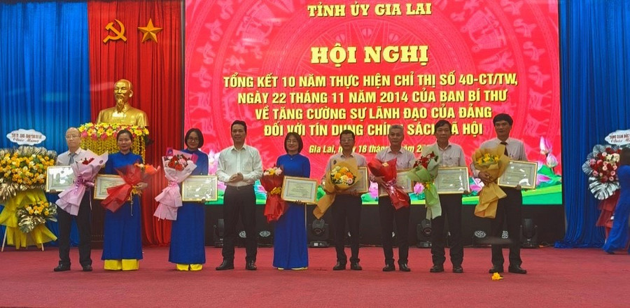 Đồng chí Hoàng Minh Tế-Phó Tổng Giám đốc Ngân hàng CSXH Việt Nam trao giấy khen của Tổng Giám đốc cho các cá nhân, tập thể có thành tích đóng góp trong 10 năm thực hiện Chỉ thị số 40-CT/TW. Ảnh: Sơn Ca